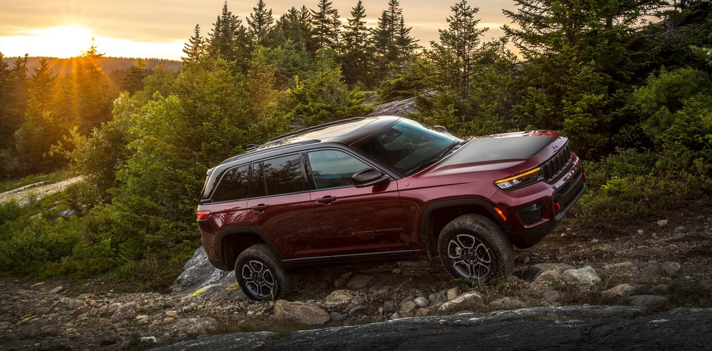 The 2022 Jeep Grand Cherokee Trailhawk being driven uphill on a rocky slope.